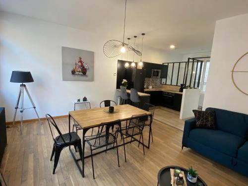 un salon avec une table et un canapé bleu dans l'établissement appt dunkerque plage de malo, à Malo-les-Bains