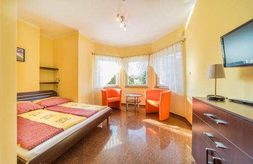 Cette petite chambre comprend un lit et une télévision. dans l'établissement Villa La Mer, à Dziwnówek