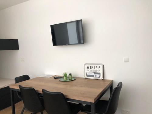 a dining room table with chairs and a tv on the wall at FLORIDE in Knokke-Heist
