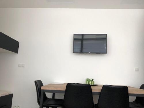 a table with chairs and a television on a wall at FLORIDE in Knokke-Heist