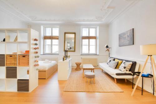 un salon blanc avec un canapé et une table dans l'établissement Le cocon des Ponts, à Nancy