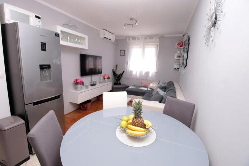 a white table with a bowl of fruit on it in a living room at Apartman *SANJA* Omiš in Omiš