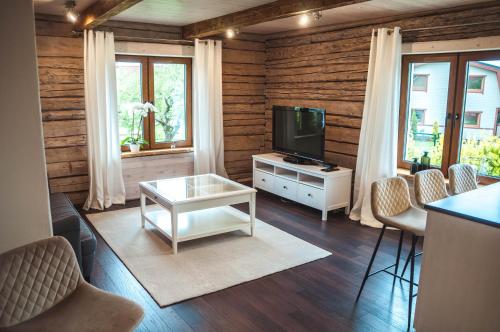 uma sala de estar com uma televisão e uma mesa e cadeiras em Klaukse em Aabla