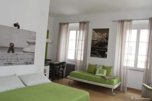 um quarto com uma cama verde e uma cadeira em Casa Griot em Trieste