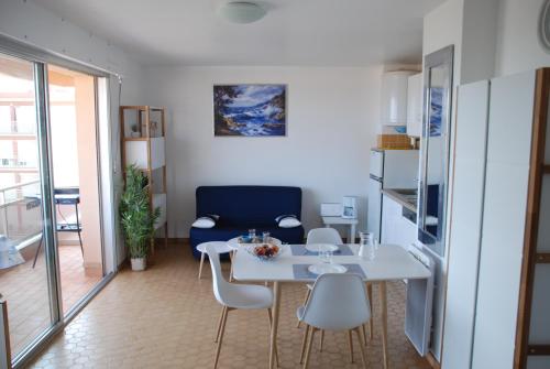 comedor con mesa blanca y sillas en Appartement Belle Vue, en Valras-Plage
