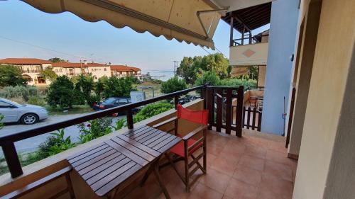 a balcony with a bench and a view of a car at Pansion Fani in Ouranoupoli