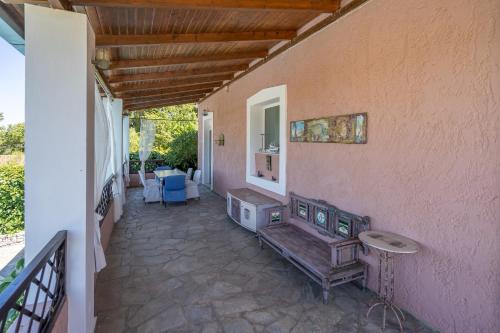 a patio with a bench and a table on a wall at Dryades Villa in Arménoi