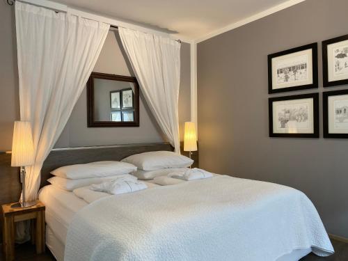 1 dormitorio con 1 cama blanca y 2 almohadas en Bergland Hotel - Adults only, en Salzburgo