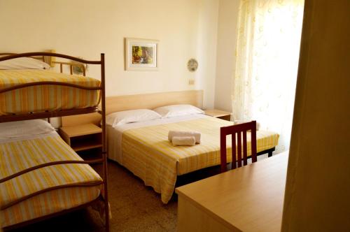 una camera con 2 letti a castello e una scrivania di Hotel Cirene a Rimini