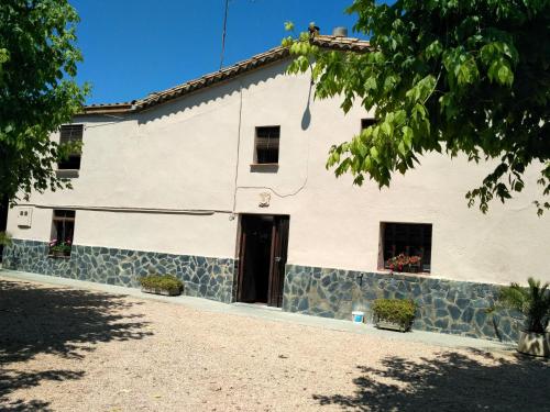 een wit gebouw met een zwarte deur en ramen bij Casa Rural "Can Abres" Vilobi d`Onyar Girona in Vilobí d'Onyar