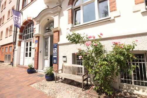 eine Holzbank vor einem Gebäude in der Unterkunft Blue Doors Hostel Altstadt in Rostock