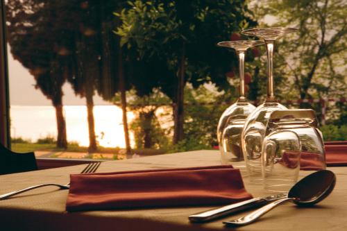 una mesa con vasos y utensilios en Hotel Baitone - Nature Village, en Malcesine