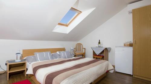 a bedroom with a bed with chairs and a window at Penzion U Králíků in Kurdějov