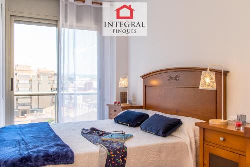 1 dormitorio con 1 cama con 2 almohadas y ventana en La Vela Apartment, en Palamós