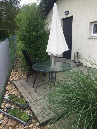 an umbrella sitting on a table in a garden at Studiový apartmán V Zahradě in Police nad Metují