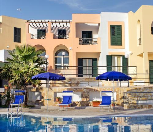 a group of chairs and umbrellas next to a swimming pool at Hotel Alizé in Santa Cesarea Terme