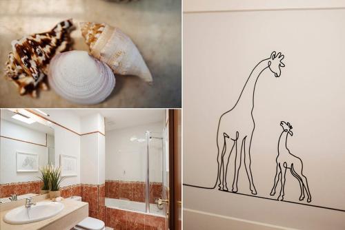 a bathroom with a giraffe stenciled on the wall at Villa Acacia in Yaiza