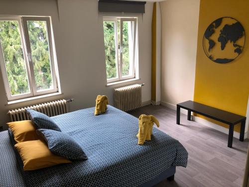 a bedroom with a blue bed with two yellow dogs on it at Villa les Tamaris in Spa