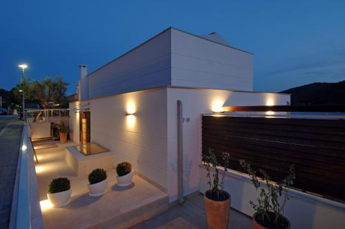 a building with potted plants on the side of it at Boutique Hotel Adoral in Rabac