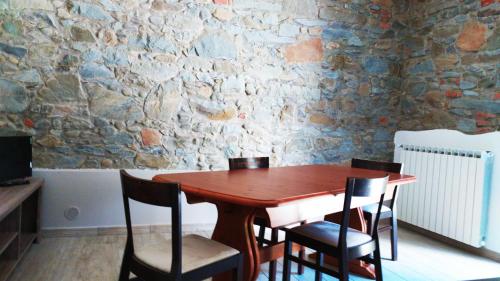 a wooden table and chairs in a room with a stone wall at La Rosa dei Venti in Cantagrillo