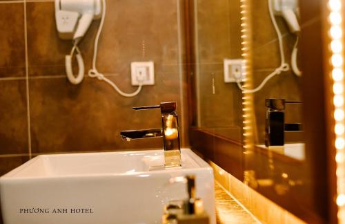 a bathroom sink with a faucet and a mirror at Khách sạn Phương Anh in HÆ°ng YÃªn