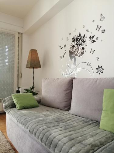 - un salon avec un canapé orné de fleurs et d'oiseaux sur le mur dans l'établissement Apt Ana, à Banja Luka