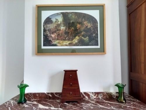 a painting hanging on a wall with a wooden cabinet at Number15 Guesthouse Carcassonne in Carcassonne