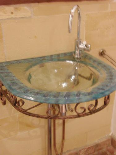 a glass sink in a bathroom with a faucet at Bed en Breakfast Hof van Wolder in Maastricht