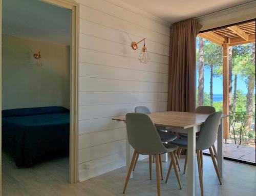 a dining room with a table and chairs at Résidence Les Pins in Calvi