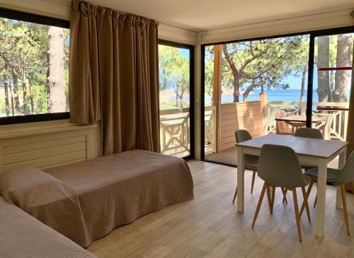 a bedroom with a bed and a table and a table and chairs at Résidence Les Pins in Calvi