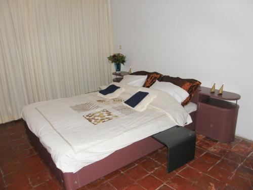 1 dormitorio con 1 cama con sábanas y almohadas blancas en Bed en Breakfast Hof van Wolder, en Maastricht