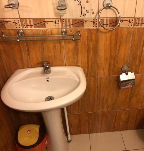 a white sink in a bathroom with wooden walls at Amani & Melisa 2 in Eforie Nord