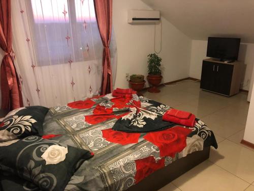 a bedroom with a bed with red and black sheets at Amani & Melisa 2 in Eforie Nord