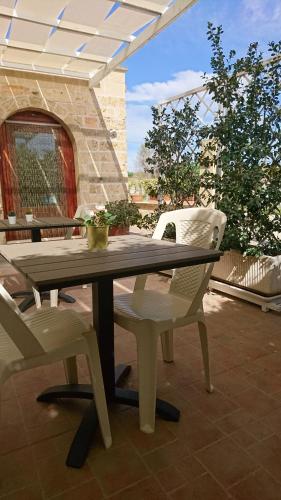 un tavolo in legno e 2 sedie su un patio di Stella Dei Campi a Sternatia
