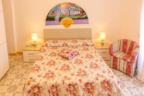 1 dormitorio con 1 cama con colcha de flores en Mini Hotel Rendez Vous en Isquia
