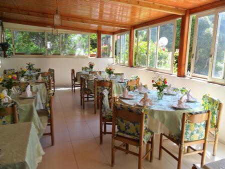 un comedor con mesas, sillas y ventanas en Mini Hotel Rendez Vous en Isquia