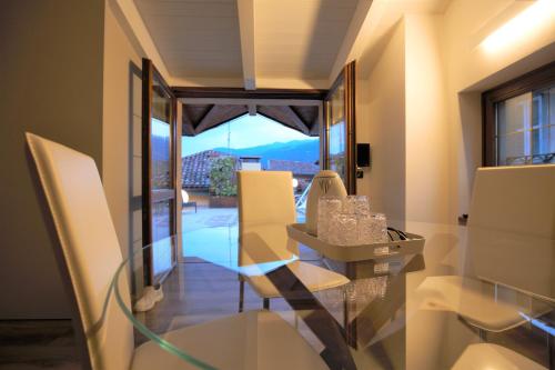 a dining room with a glass table and white chairs at Albergo Antica Locanda in Clusone