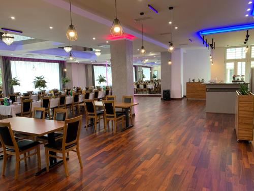 a restaurant with tables and chairs and a bar at Hotel Sybilla in Puławy