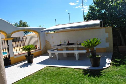 une terrasse avec une table blanche et deux plantes en pot dans l'établissement EL ROCIO 2, à Saintes-Maries-de-la-Mer