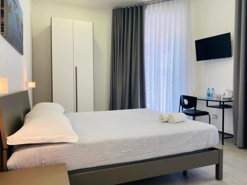 una camera con un letto, una sedia e una finestra di InCentroScalea B&B a Scalea