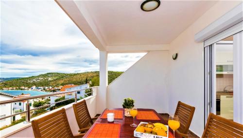 a balcony with a table and chairs and a view of the ocean at Apartment Dora in Ražanj