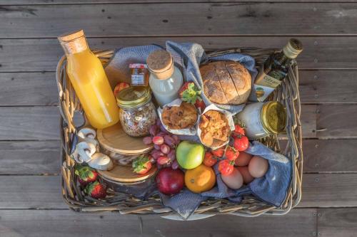 a basket full of food and fruit on a wooden table at Currajong Retreat in Burragate