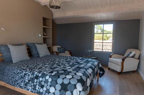 une chambre avec un lit et deux chaises et une fenêtre dans l'établissement Sea-Snow Guest Houses, à Talmont-Saint-Hilaire