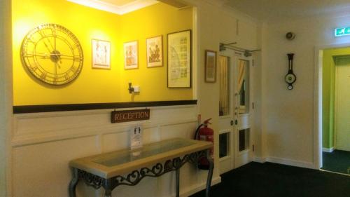 肯萊恩的住宿－嘉樂威蘭斯酒店，墙上挂着钟的黄色墙
