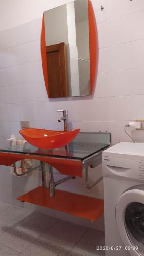 baño con lavabo rojo y espejo en casa Antony en San Teodoro