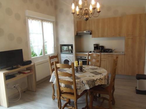 cocina con mesa y sillas y comedor en petite maison de vacance, en Grandcamp-Maisy