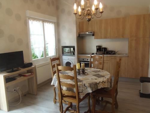 a kitchen with a table and chairs and a dining room at petite maison de vacance in Grandcamp-Maisy