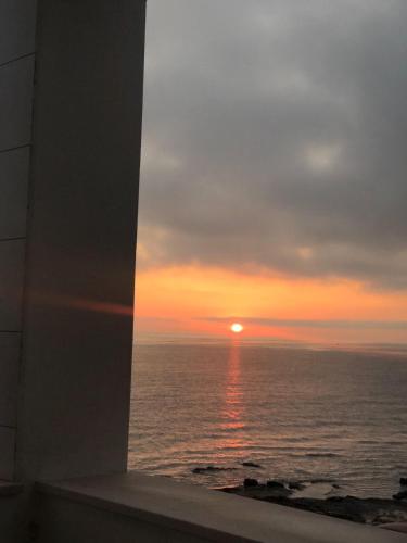 a sunset view from a window of the ocean at Palese Profumo di Mare in Santo Spirito