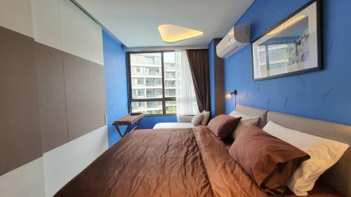 a bedroom with a large bed with a blue wall at Santorini Khao Takiab Huahin Beach Front in Hua Hin