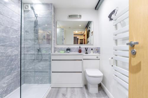 a white bathroom with a shower and a toilet at Historic Location, Private Parking, Ground Floor Luxury Flat in Aberdeen